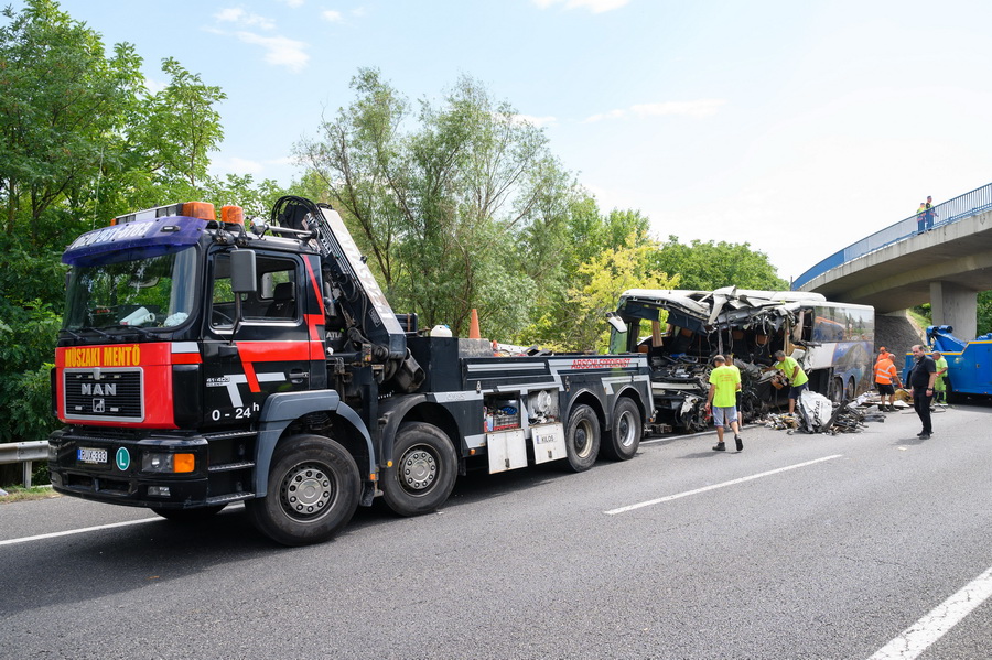Szabadbattyán, 2021. augusztus 15.
Elvontatáshoz előkészítik a hajnalban árokba hajtott autóbuszt az M7-es autópálya mellett Szabadbattyán közelében 2021. augusztus 15-én. A balesetben Nyolcan meghaltak, nyolcan sérültek meg súlyosan, negyvenen könnyebben. A buszon Horvátországban nyaraló magyar turisták utaztak.
MTI/Vasvári Tamás