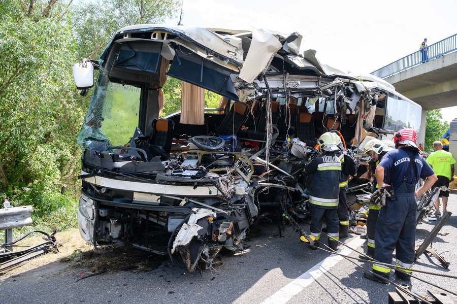 Szabadbattyán, 2021. augusztus 15.
Tűzoltók az árokból kiemelt, hajnalban balesetet szenvedett autóbusznál az M7-es autópálya mellett Szabadbattyán közelében 2021. augusztus 15-én. A balesetben nyolcan meghaltak, nyolcan sérültek meg súlyosan, negyvenen könnyebben. A buszon Horvátországban nyaraló magyar turisták utaztak.
MTI/Vasvári Tamás